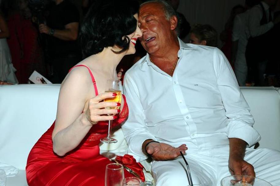 Dita Von Teese sorseggia champagne con il festeggiato, il gioielliere Fawaz Gruosi, avvolta in un vestitino super sexy rosso, tema cromatico della serata  per tutte le  ospiti. (foto Olycom)